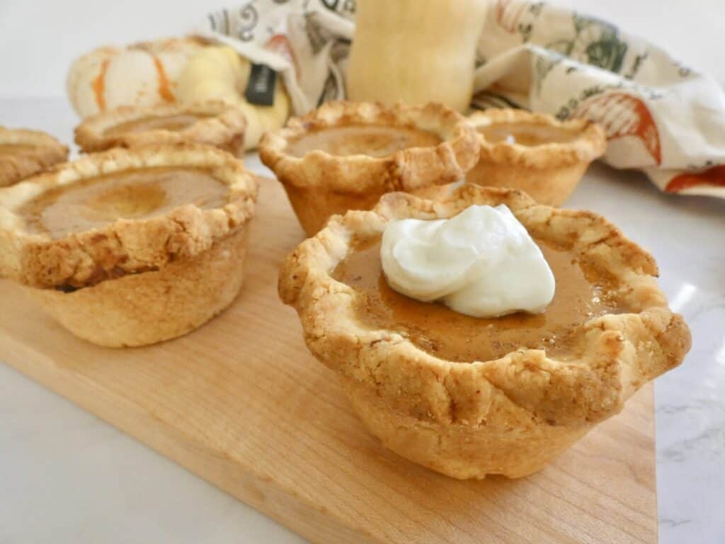 close up of mini pumpkin pies with cream