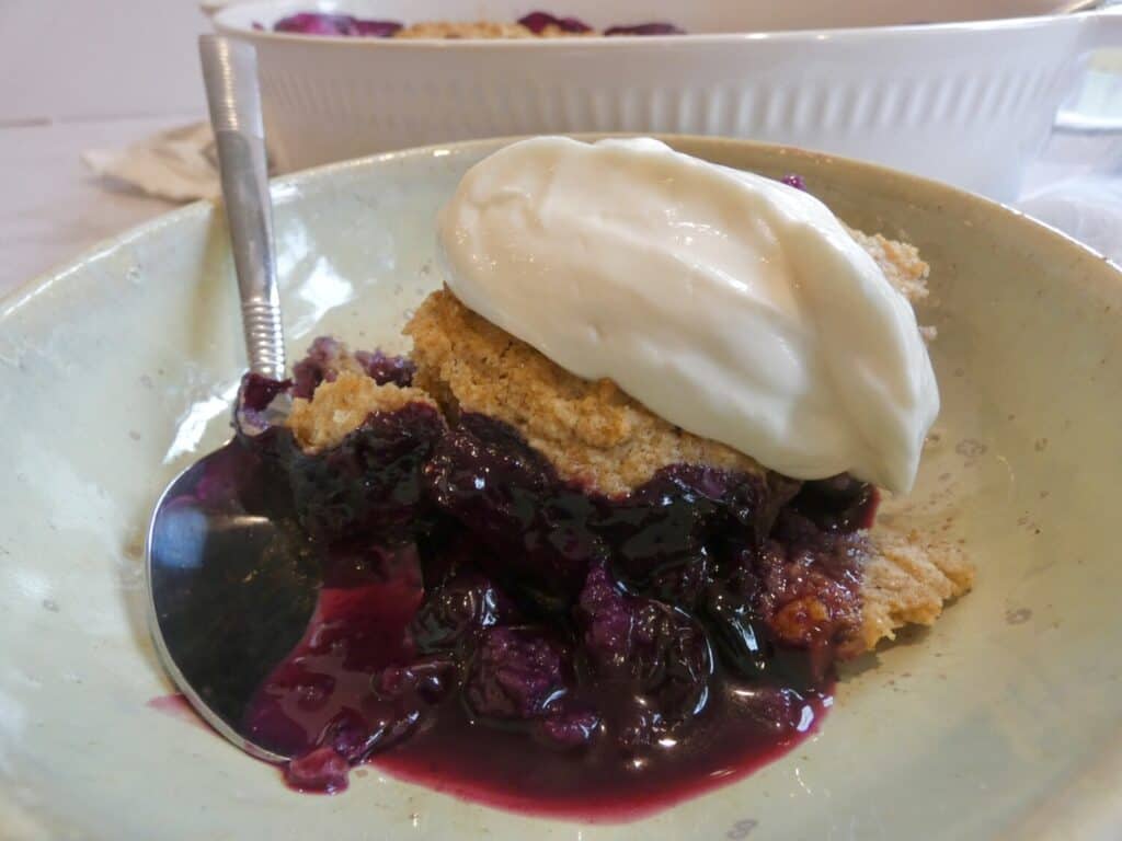 scoop of healthier blueberry cobbler in a bowl