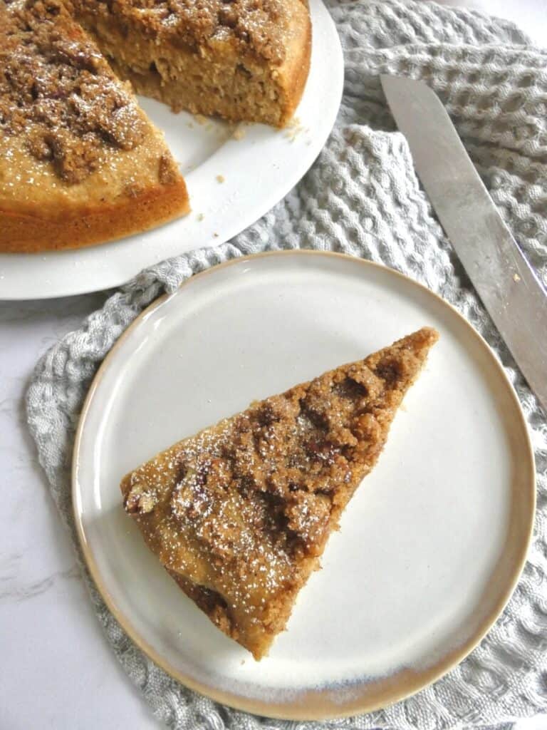 slice of apple cider coffee cake with pecan streusel with cake knife