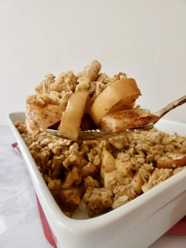 Healthy apple crumble on spoon vertical