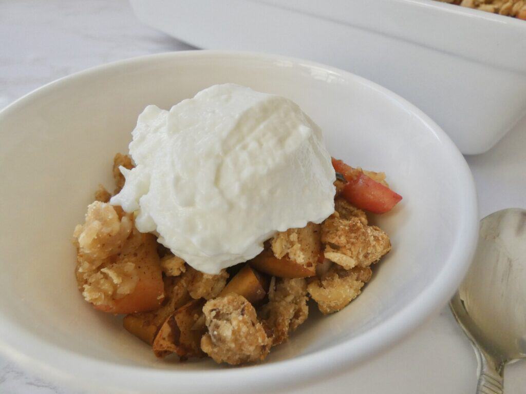 Healthy apple crumble in a bowl with vanilla ice cream