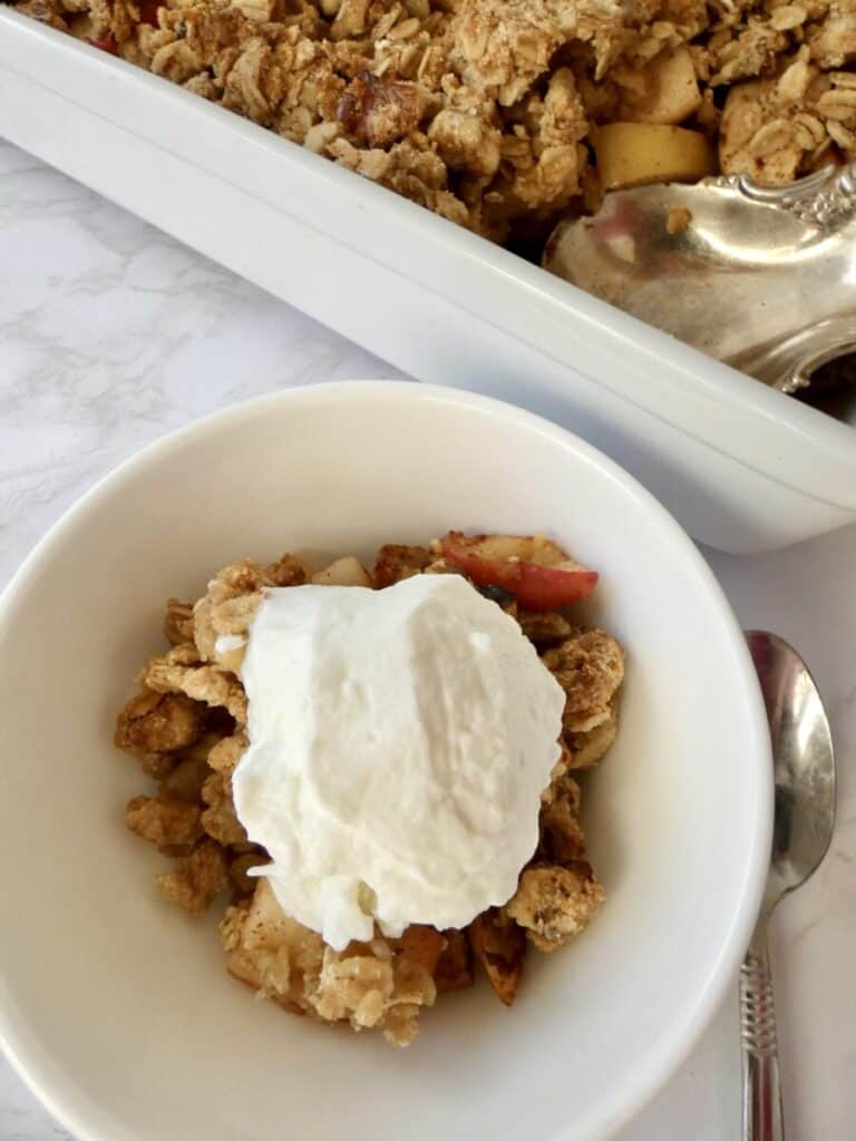 Healthy apple crumble with vanilla ice cream vertical orientation