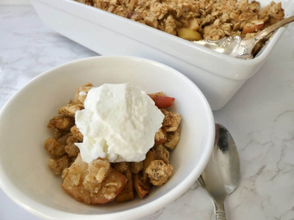 Healthy apple crumble in a bowl with ice cream