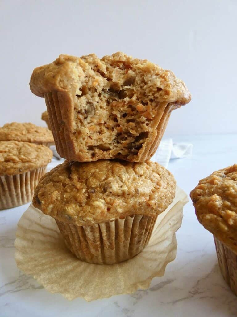 vertical close up of healthy carrot cake muffin with bite missing