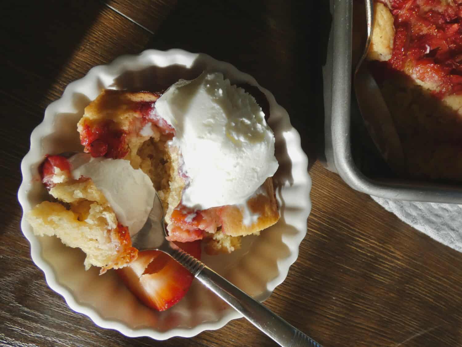 bowl of Easy Jammy Strawberry Cake with vanilla ice cream