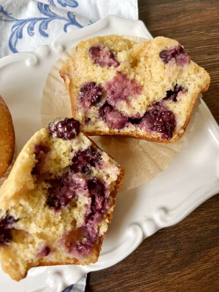 two halves of a healthier blackberry cornbread muffin on a plate