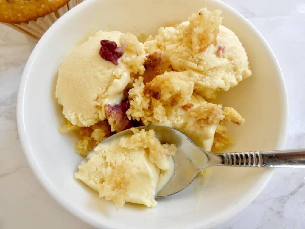 bowl of sweet corn ice cream topped with cornbread