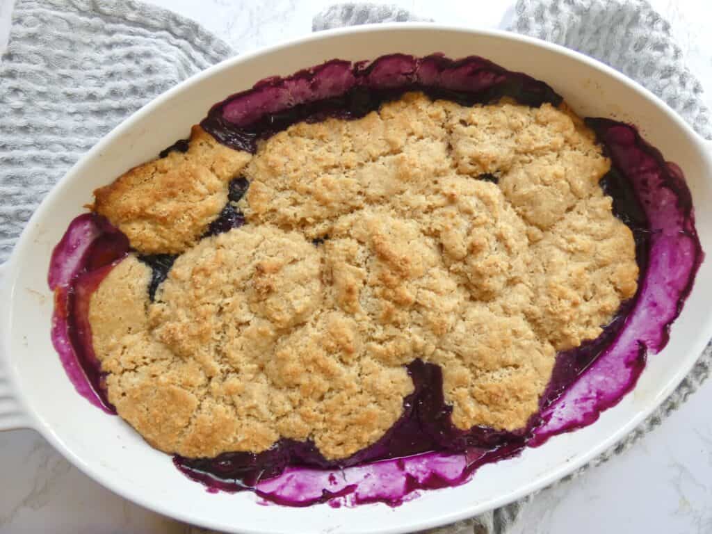 top down view of healthier blueberry peach cobbler in baking dish