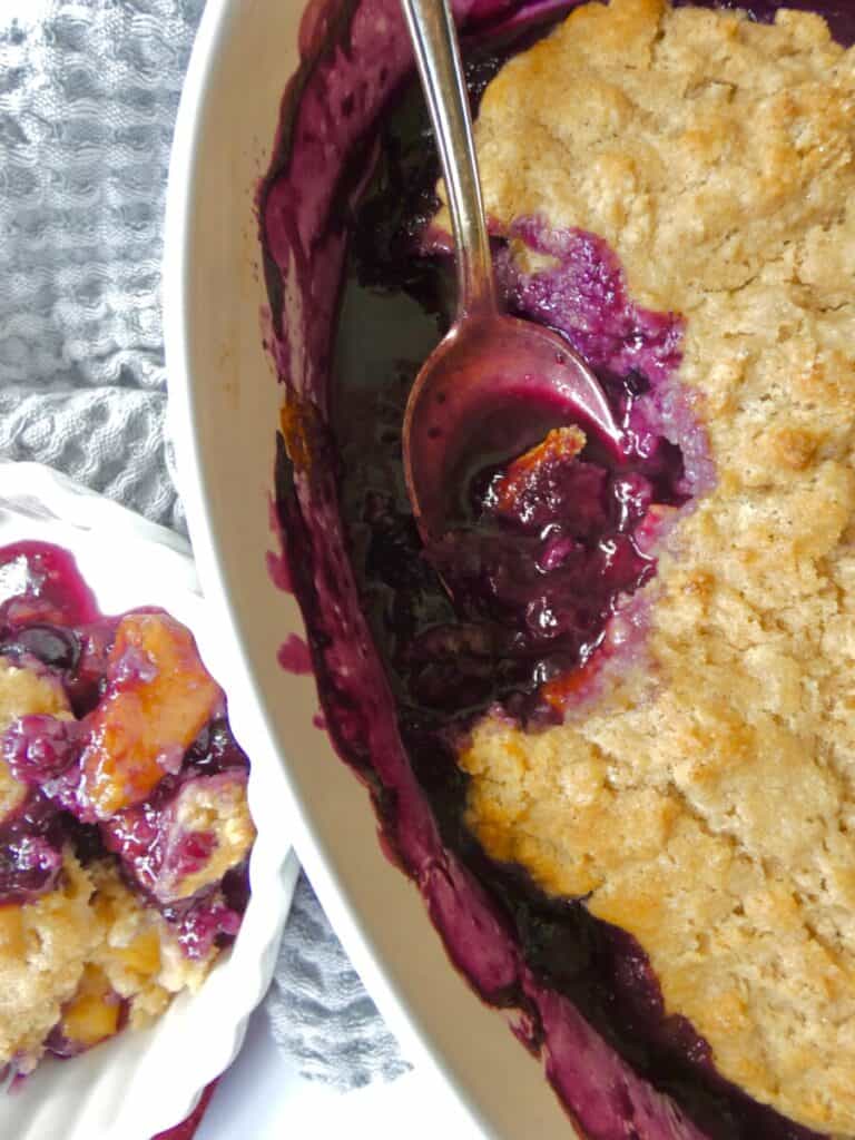 close up of healthier blueberry peach cobbler in baking dish