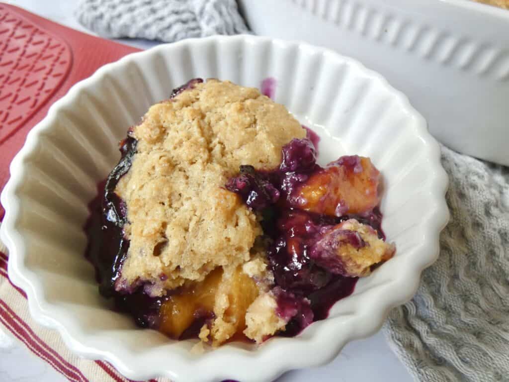 close up of a bowl of healthier blueberry peach cobbler