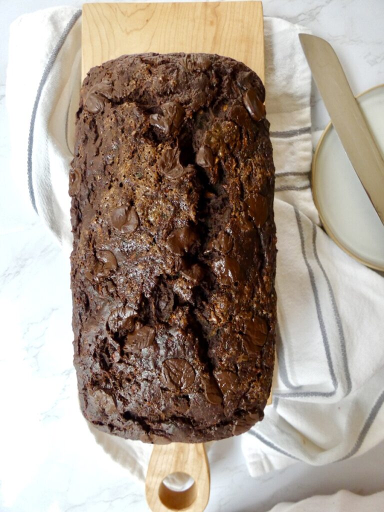 vertical image of full loaf of healthier double chocolate zucchini bread before slicing