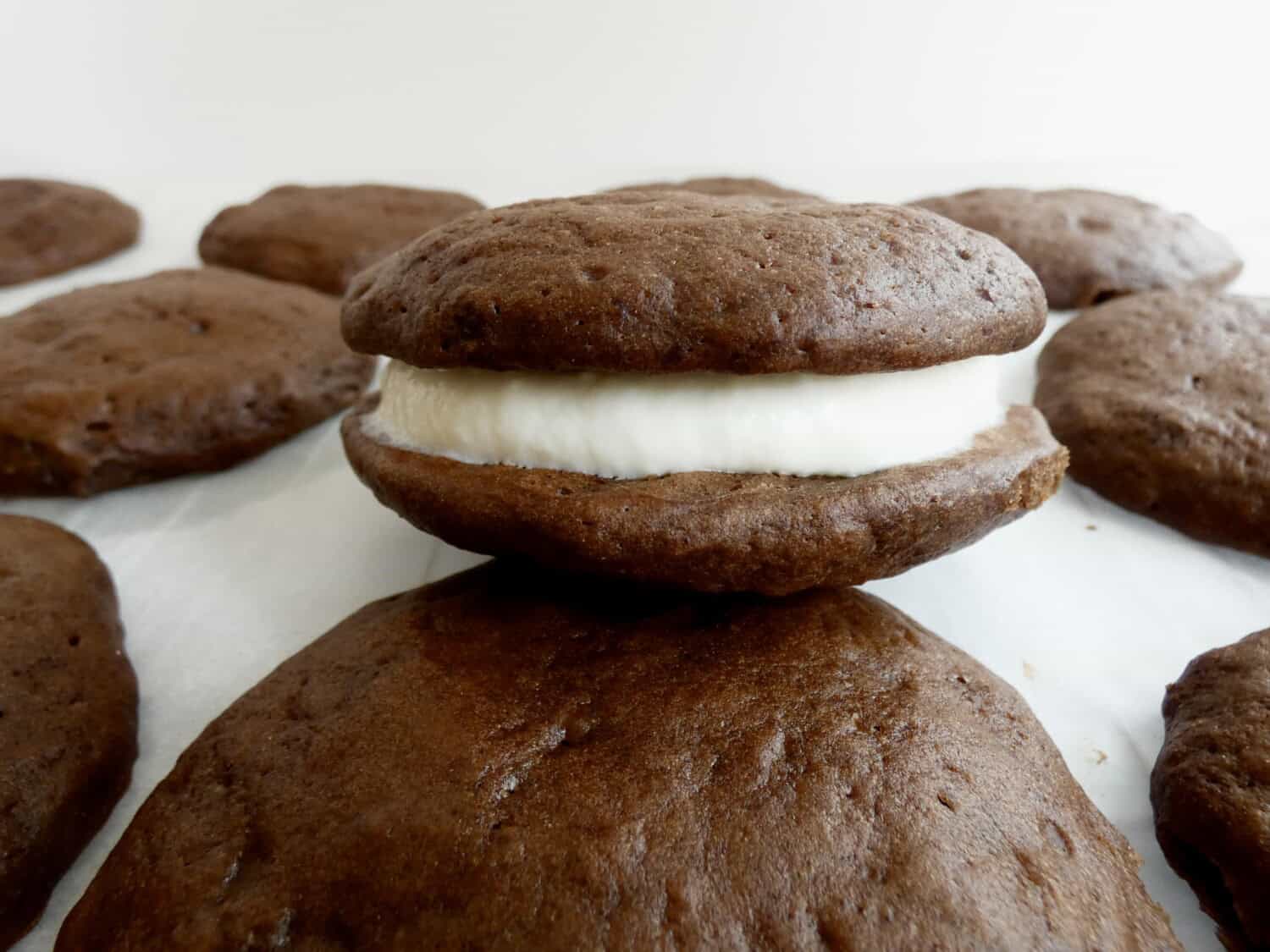 close up of a healthier chocolate whoopie pie on parchment paper