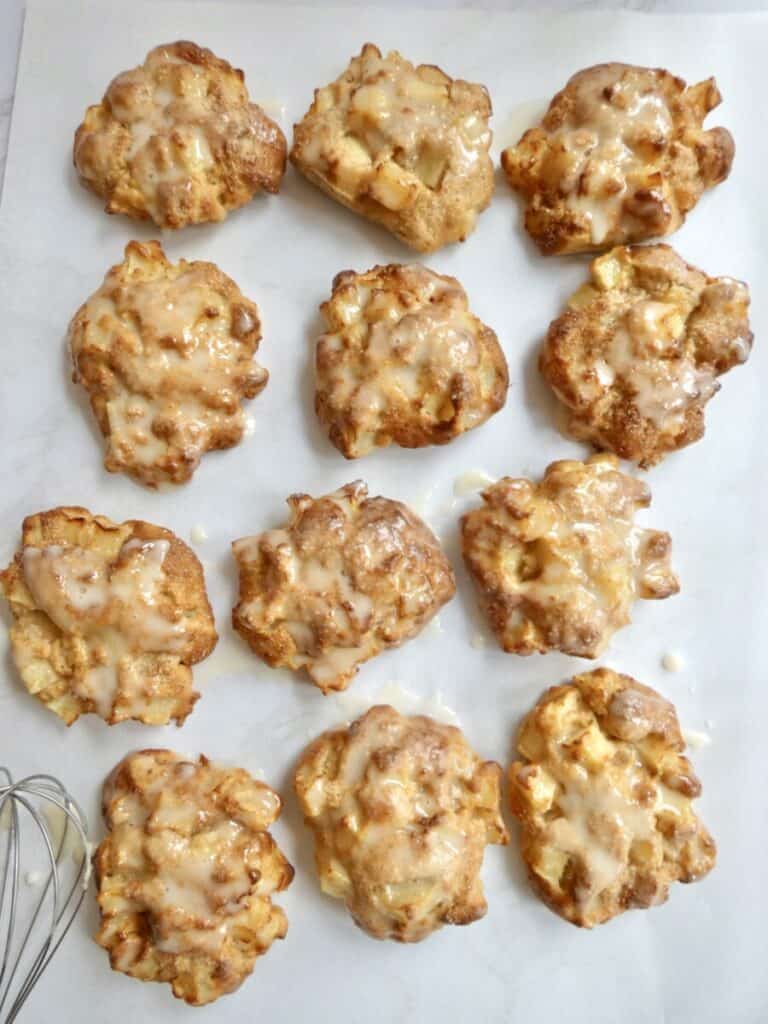 glazed air fryer apple fritters on parchment paper