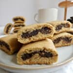 close up of Healthy Homemade Fig Newtons on a round plate with a bowl of dried figs in the background