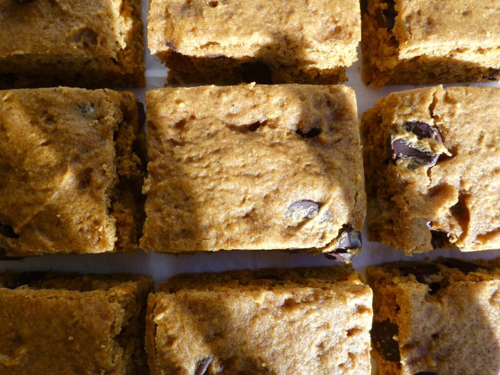 top down view of browned butter chocolate chip pumpkin bars on parchment paper