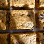 Top down view of browned butter chocolate chip pumpkin bars on parchment paper