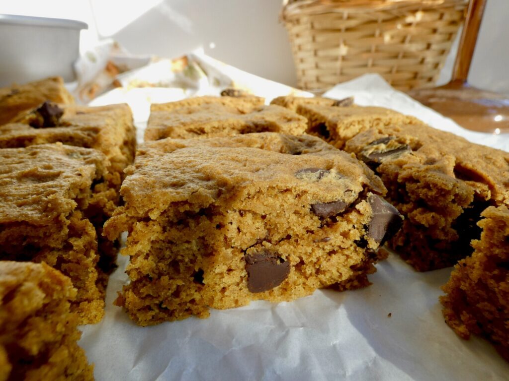 close up of browned butter chocolate chip pumpkin bars on parchment paper