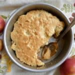 top down view of Eve's Pudding with cinnamon sticks and apples in the background