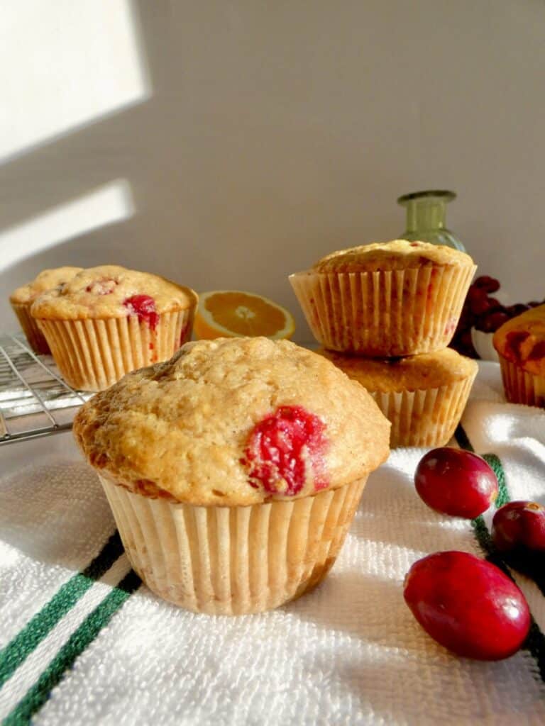 Cranberry Orange Muffin surrounded by fresh cranberries and oranges